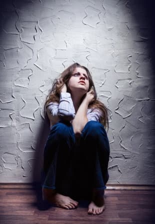 Addict girl sitting on the floor alone