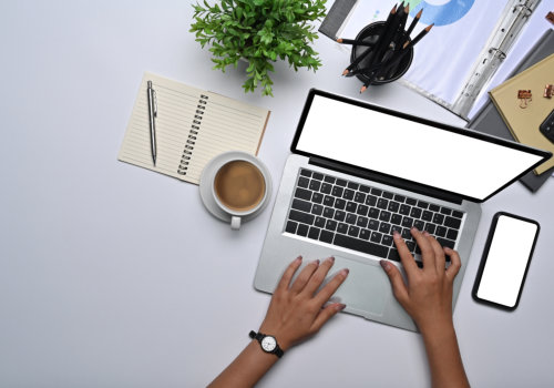Overhead view businesswoman working with laptop on white office desk.